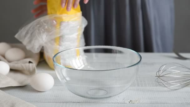La mujer vestida de gris llena la harina en un bol. Casa mesa de cocina
 - Imágenes, Vídeo