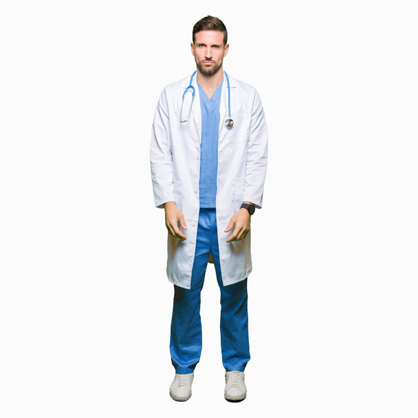 Όμορφος ο γιατρός άνθρωπος φορώντας ιατρική στολή πάνω από τα απομονωμένα φόντο κατάθλιψη και ανησυχία για την αγωνία, κλάμα, θυμωμένος και φοβισμένος. Θλιβερή έκφραση. - Φωτογραφία, εικόνα