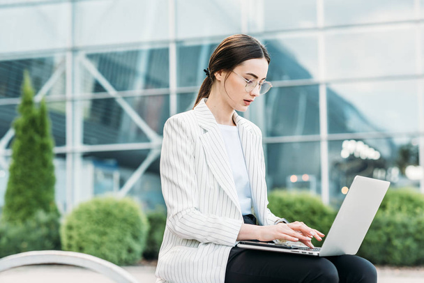 Successful businessman working at laptop. Business woman working. Sales woman working using her laptop while writing text. Businesswoman in glasses working on-line. Mobile technology. - Fotó, kép