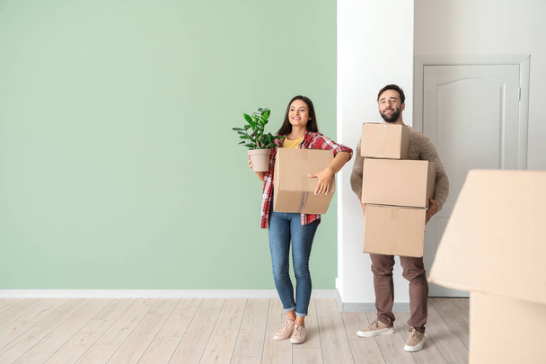 Feliz pareja joven con cajas de cartón en su nueva casa
 - Foto, imagen