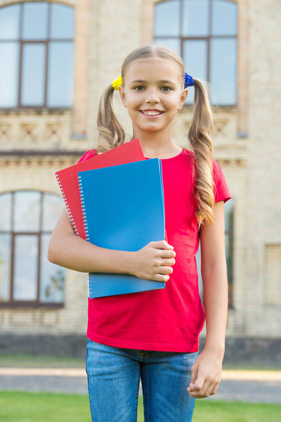 Cute little bookworm. Cute smiling small child hold books educational institution background. Adorable little girl school student. Secondary school student. Study language. School education concept - Foto, afbeelding