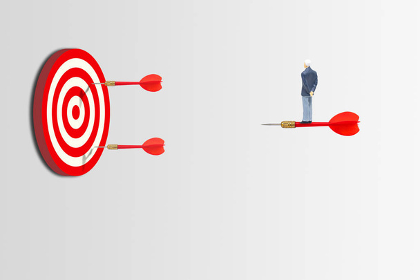 Üzleti és marketing koncepció: üzletember állva piros Dart, hogy a rohanó cél a Dart tábla. - Fotó, kép