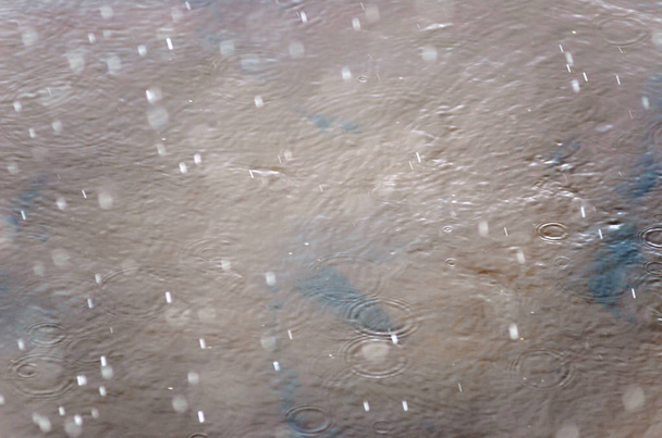Фото падаючих крапель граду і дощу зі швидкою швидкістю розбиті на водяній поверхні річки з колами восени
. - Фото, зображення