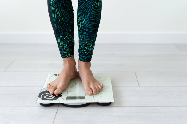 Young sporty woman standing on flooring scale weight - Photo, Image