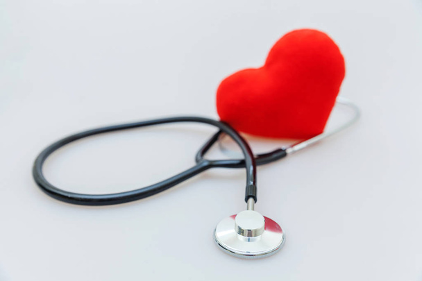 薬の機器聴診器や音声鏡と赤い心臓は、白い背景に隔離されています。医師のための器械装置。医療保険の概念 - 写真・画像