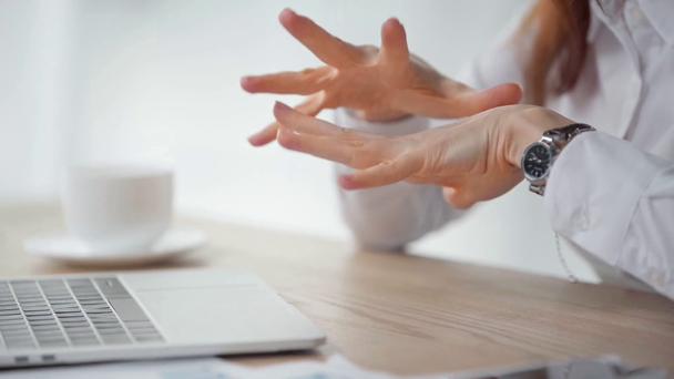 visão parcial de empresária massageando as mãos e usando laptop
 - Filmagem, Vídeo