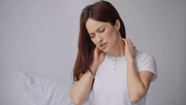 piękna kobieta cierpiąca na ból szyi w sypialni - Materiał filmowy, wideo