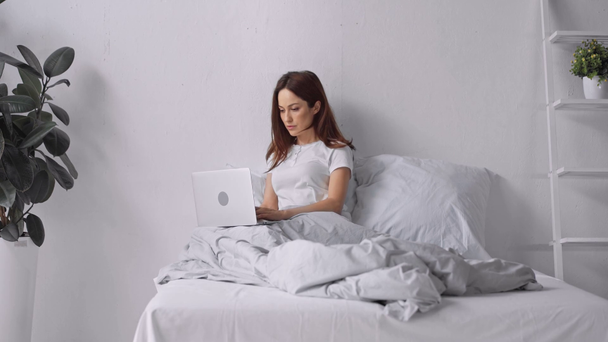 hermosa mujer trabajando en el ordenador portátil en la cama
 - Imágenes, Vídeo