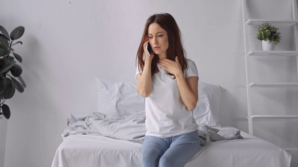 Traurige Frau mit Migräne spricht auf Smartphone - Filmmaterial, Video