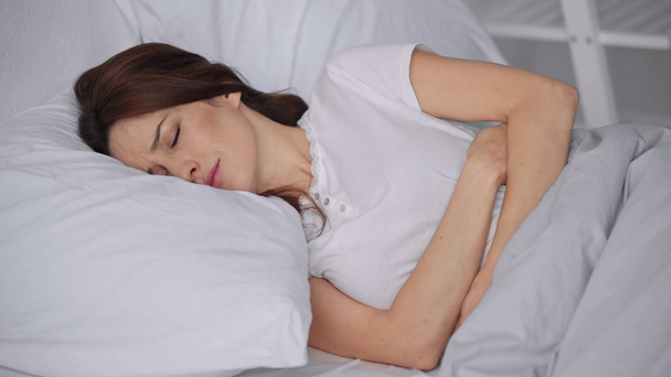 donna sdraiata a letto e affetta da mal di stomaco
 - Filmati, video