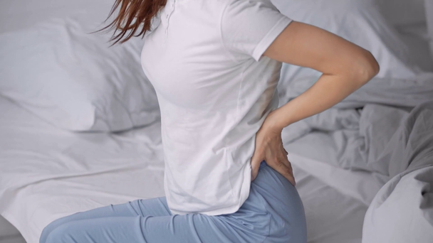 mujer despertando y sufriendo de dolor de espalda en la cama
 - Imágenes, Vídeo