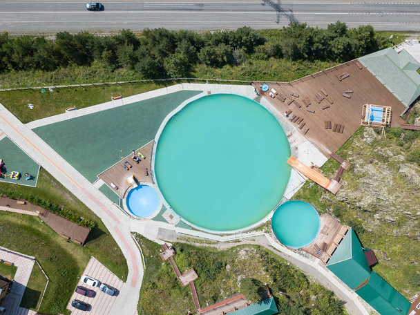 Vista aérea de um centro de recreação turística com três nadadores
 - Foto, Imagem
