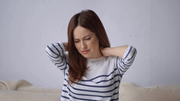 Frau im gestreiften Oberteil leidet unter Nackenschmerzen - Filmmaterial, Video