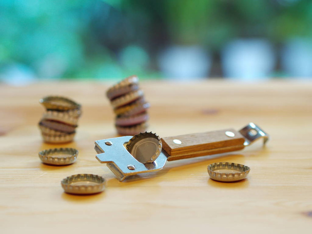 Bottle Opener with a cap on a wooden table. Natural Light. - Photo, Image
