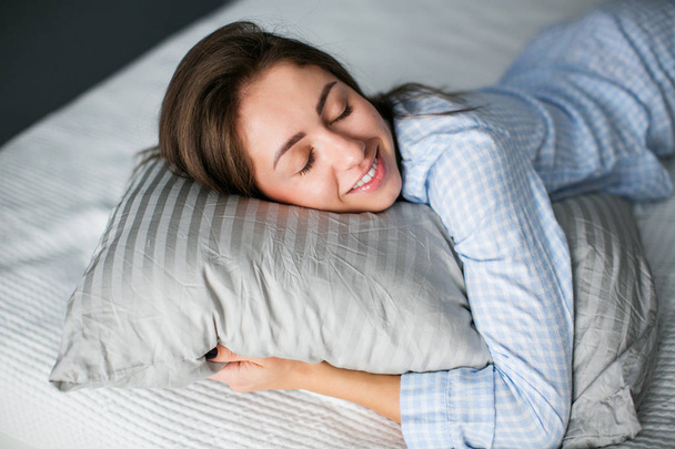Beautiful young woman sleeping in her bedroom. - Фото, изображение