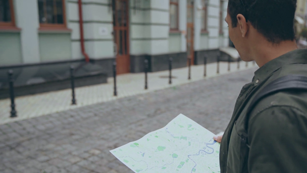 dvourasový muž Procházka s mapou podél ulice - Záběry, video