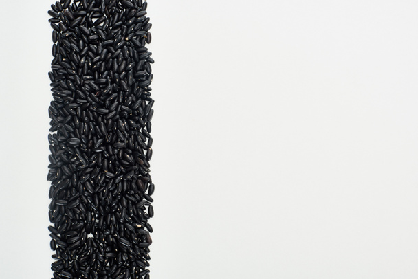 Κορυφαία θέα των μικρών μαύρων φασολιών που απομονώνονται σε λευκό - Φωτογραφία, εικόνα