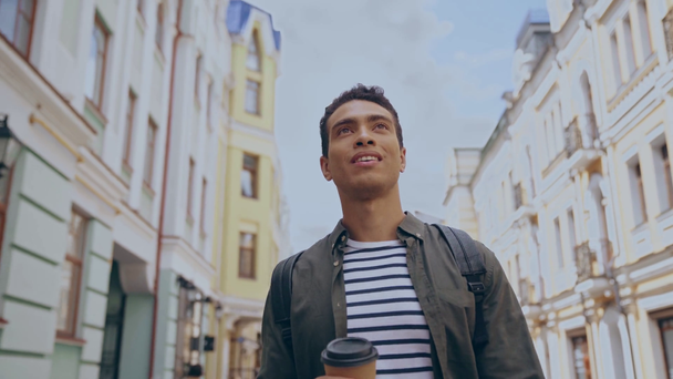 homem bi-racial andando com copo de papel
 - Filmagem, Vídeo