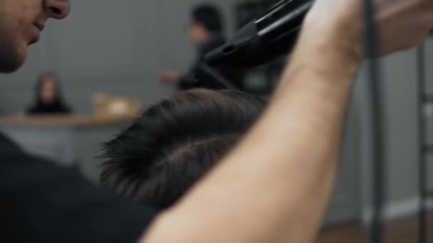 Close-up of barber doing styling with a handsome man with a long beard. Hairdressers hands at working process. Barber making haircut of attractive bearded man in barbershop. Hairdresser at work. - Záběry, video