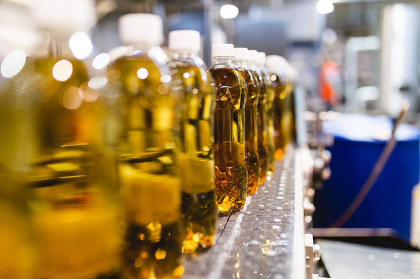 Bottling factory - Apple juice bottling line for processing and bottling juice into bottles. Selective focus.  - Photo, Image