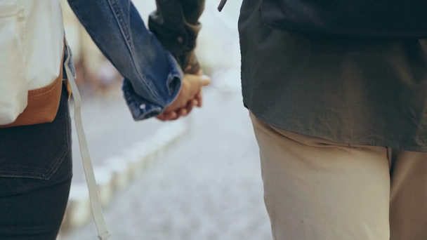 περικομμένη θέα του διαφυλετικός ζευγάρι κρατώντας τα χέρια - Πλάνα, βίντεο