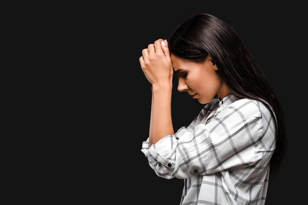вид збоку засмучена молода жінка торкається голови ізольовано на чорному
  - Фото, зображення