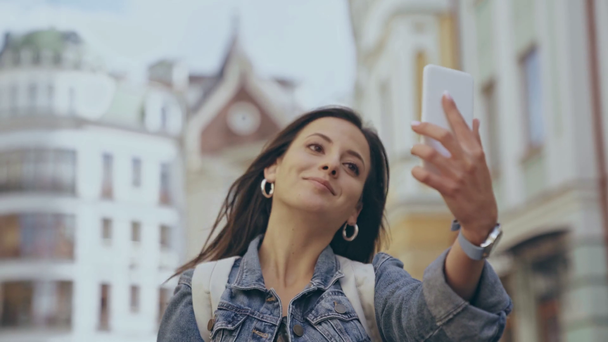 νεαρή γυναίκα που συσκευάζουν selfie στο δρόμο - Πλάνα, βίντεο