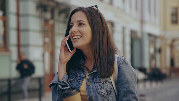 vrouw drinken koffie en praten op smartphone op straat - Video