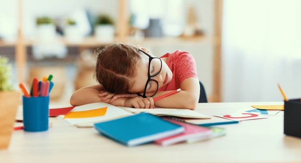 menina criança cansado adormeceu quando ela fez seu dever de casa em casa
 - Foto, Imagem