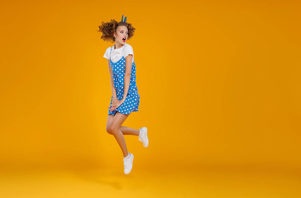 concept happy emotional young woman in blue  jumping   on yellow - 写真・画像