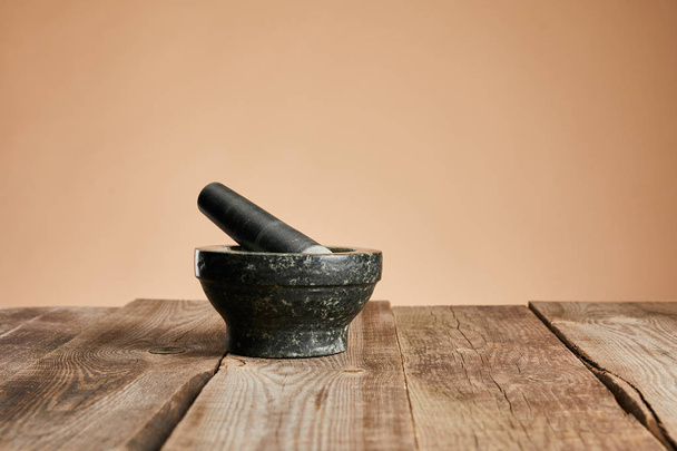 grey stone mortar on wooden table isolated on brown - Φωτογραφία, εικόνα