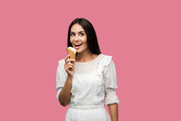ピンクに隔離されたおいしいアイスクリームを保持するドレスで幸せな女性  - 写真・画像