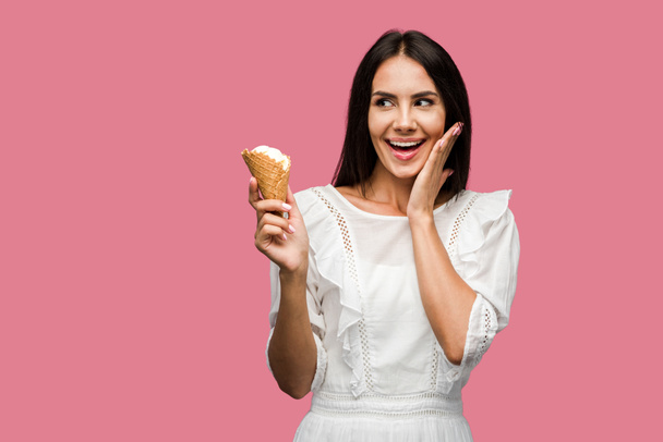 excited woman in dress holding tasty ice cream cone isolated on pink  - Fotoğraf, Görsel