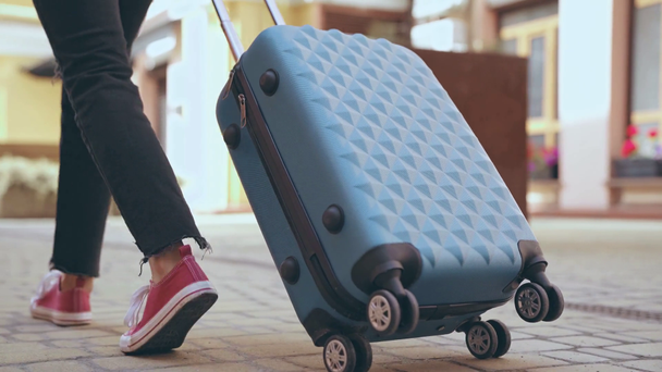 обрезанный вид женщины, идущей с чемоданом
 - Кадры, видео