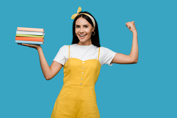 femme heureuse dans le bandeau tenant des livres et geste isolé sur bleu
  - Photo, image