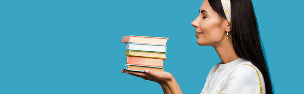 panoramic shot of woman holding books isolated on blue  - Foto, immagini