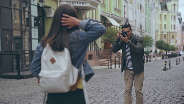 KYIV, UKRAINE - JULY 9, 2019: bi-racial man taking picture of his girlfriend - Felvétel, videó