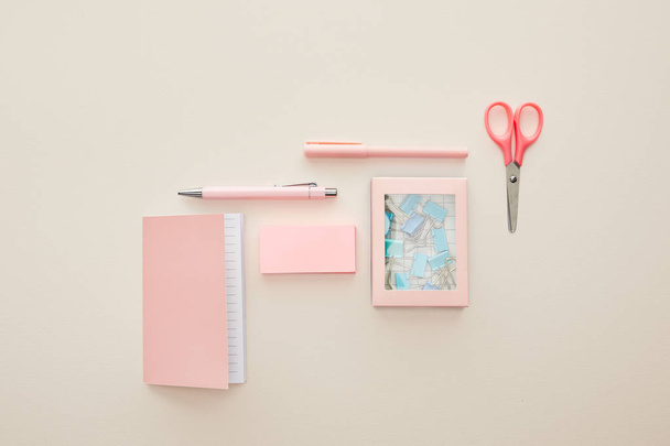 vista superior de papelería rosa cerca de la caja con clips de papel aislados en beige
  - Foto, Imagen