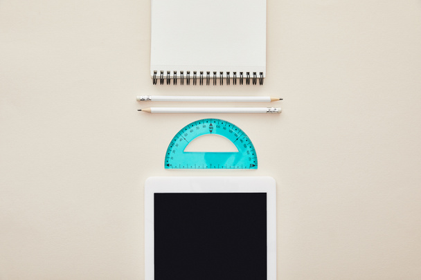 widok z góry ołówków, notebooka i linijki w pobliżu tabletu cyfrowego z pustym ekranem izolowanym na beżu  - Zdjęcie, obraz