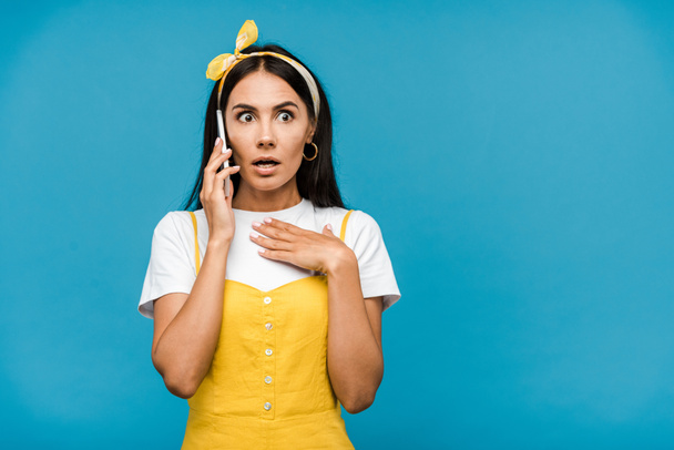 shocked girl talking on smartphone isolated on blue  - Foto, immagini