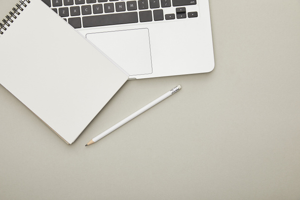 top view of laptop with notebook and pen isolated on grey  - Photo, Image