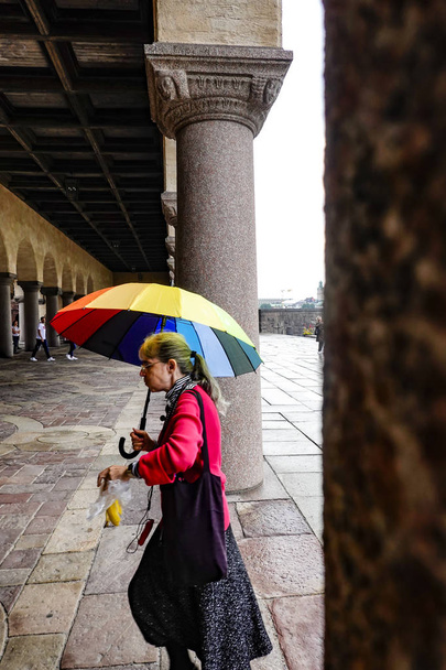 Estocolmo, Suecia Una mujer pasa por el Ayuntamiento o Stadshuset con un paraguas brillante
. - Foto, imagen