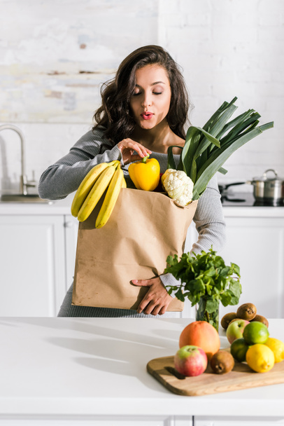 красивая женщина стоит рядом с бумажным пакетом с вкусной едой
  - Фото, изображение
