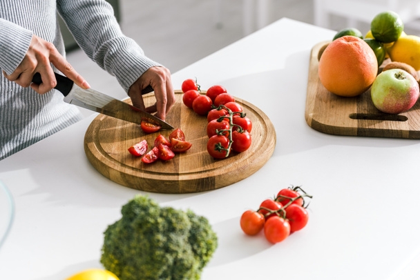 foyer sélectif de femme tenant couteau près de tomates cerises
  - Photo, image