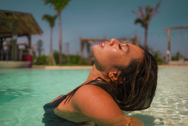 young beautiful and happy Asian Indonesian woman in bikini swimming in tropical island pool resort enjoying luxury and exotic Summer holidays - Fotó, kép