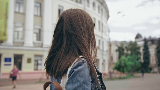 jovem mulher andando ao longo da rua com edifícios
 - Filmagem, Vídeo