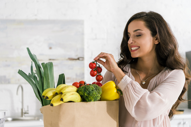 happy young woman holding red cherry tomatoes  - Foto, Bild