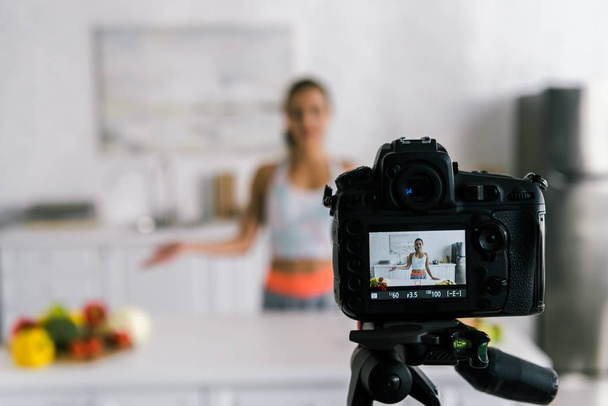 mise au point sélective de l'appareil photo numérique avec femme gesticulant près des légumes à l'écran
  - Photo, image