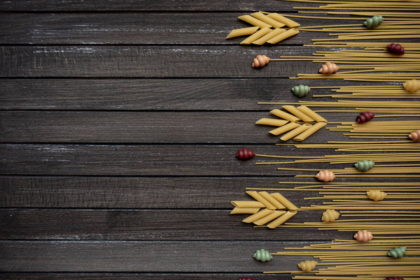 Tasty appetizing classic Italian spaghetti pasta on a dark wooden background. view from above. horizontal - Foto, afbeelding
