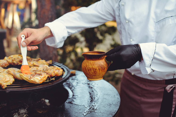 Şef ızgarada et pişiriyor. Altın ızgara kaburga ve tavuk biftek, lezzetli yemek - Fotoğraf, Görsel